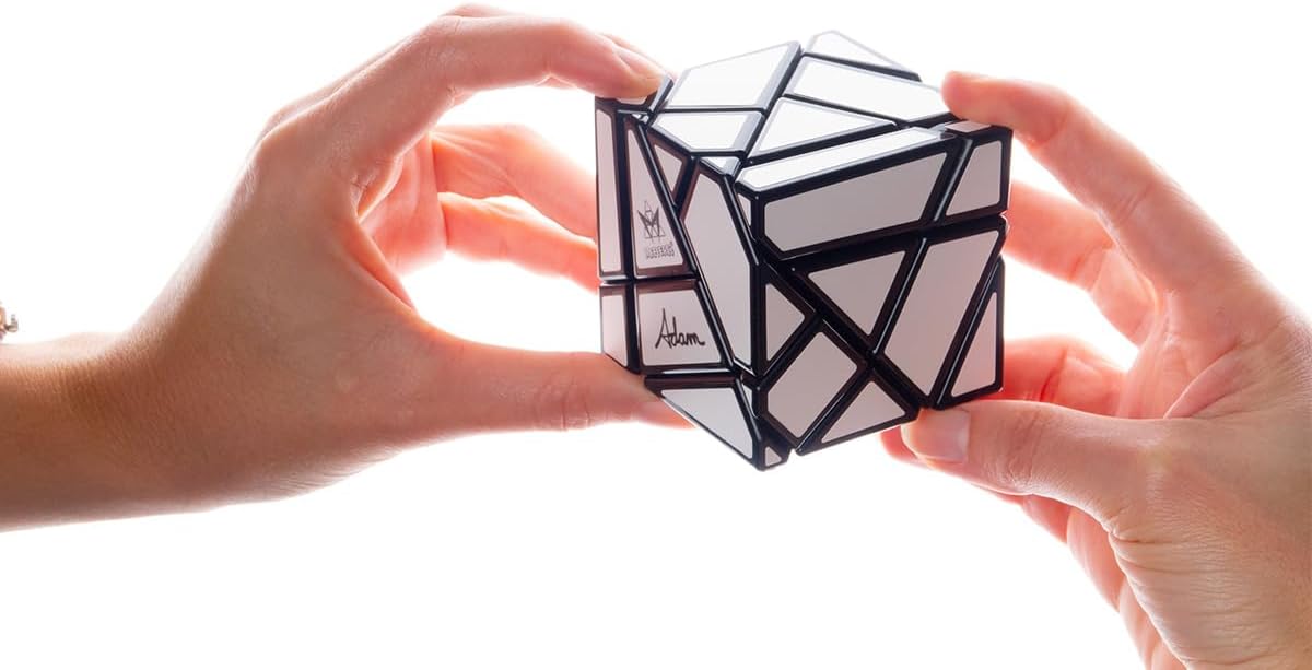 Two hands holding Meffert’s Ghost Cube, a black and white shape-shifting puzzle, against a bright white background.