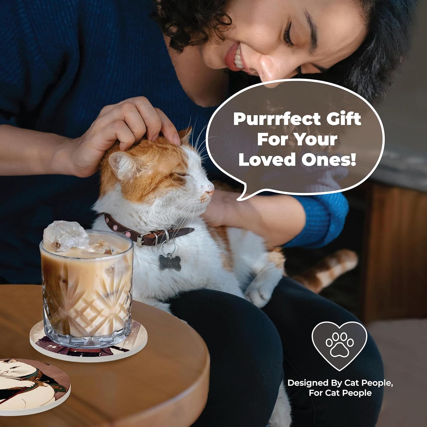 Person petting an orange-and-white cat next to a glass of iced coffee on a samurai cat coaster. Text: "Purrfect Gift For Your Loved Ones!" and "Designed By Cat People, For Cat People" with a paw heart icon.