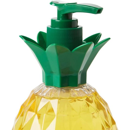 The upper half of a pineapple-shaped soap dispenser with a faceted yellow body resembling a real pineapple and a green pump top designed to look like pineapple leaves. The dispenser is filled with yellow liquid soap, adding to its tropical aesthetic.