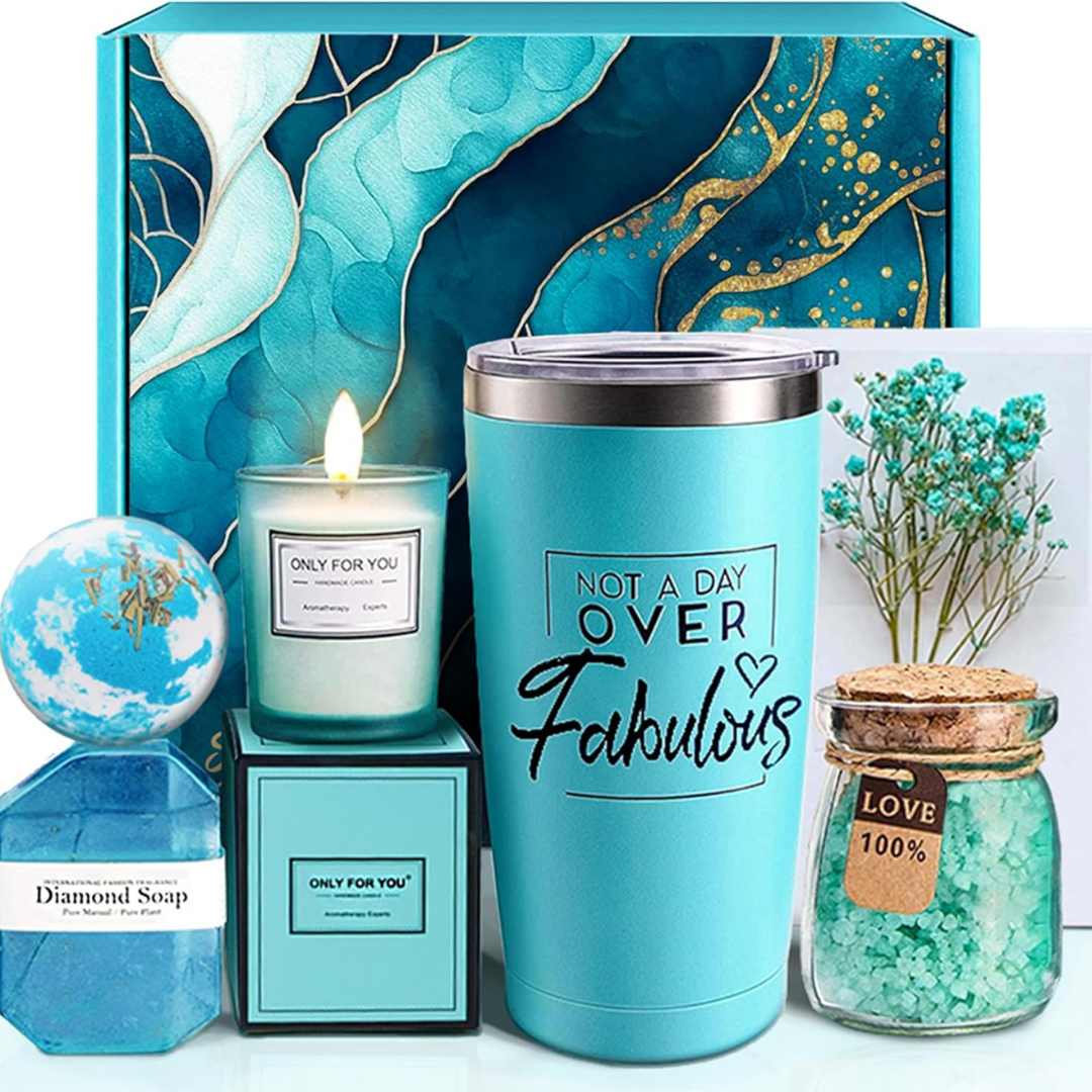 A women's self care package including a candle, tumbler, bath salts, bath bomb and a gift card.