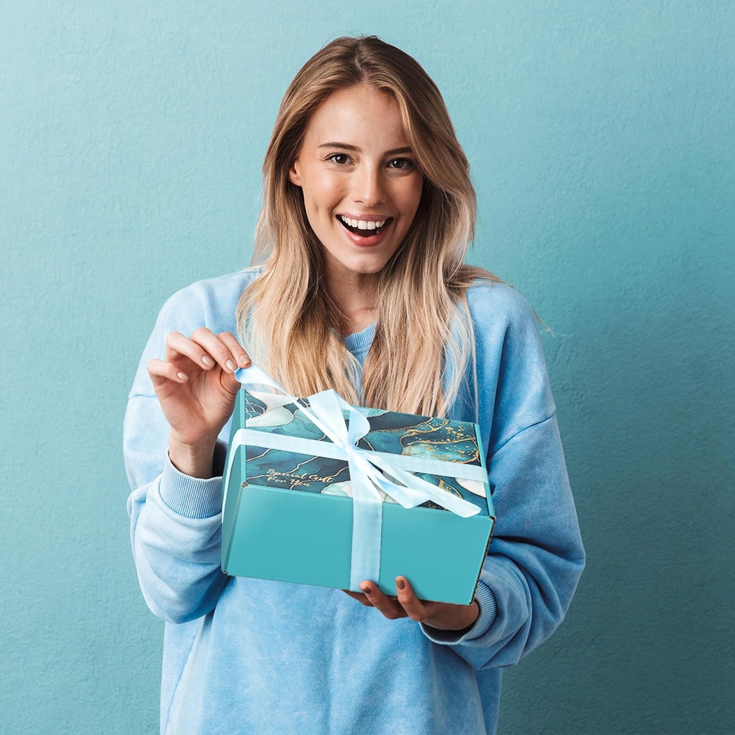 A women opening a gift wrapped self care package.