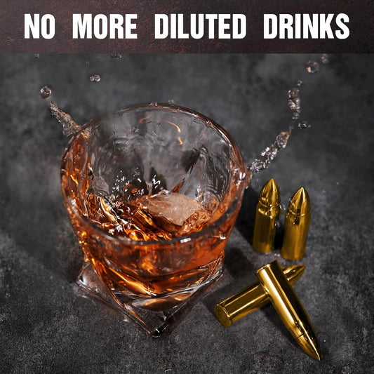 A glass of splashing whiskey with four bullet shaped whiskey stones beside the glass.