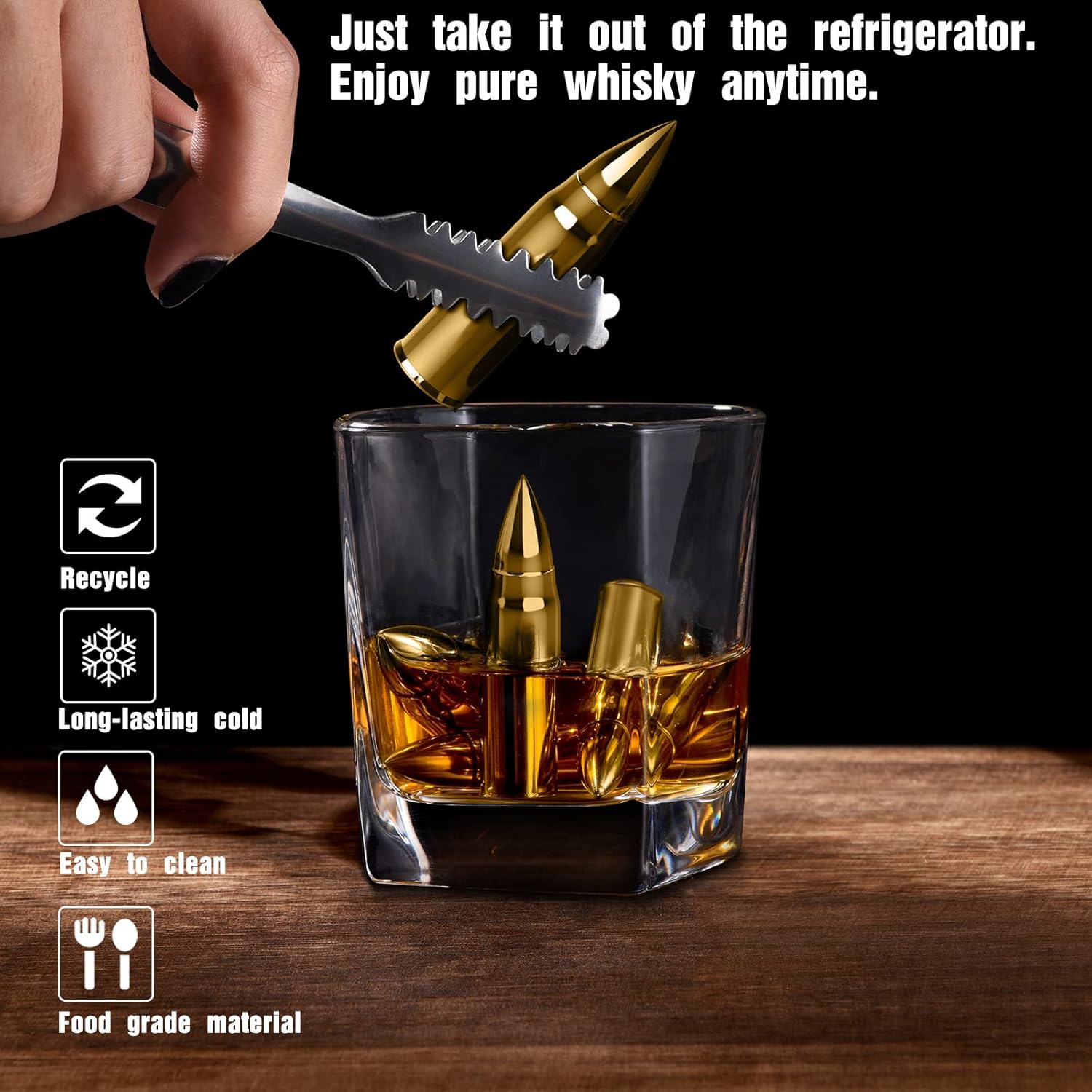 A glass of whiskey with metallic, bullet-shaped whiskey stones inside, keeping the drink cool without dilution. A hand uses tongs to place another golden bullet-shaped stone into the glass. The background is dark, with text highlighting the product’s features such as recyclability, long-lasting cold retention, ease of cleaning, and food-grade material.